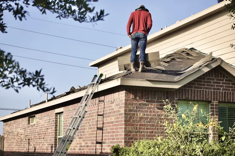 Professional roofer working on a residential roof in Outlet Area